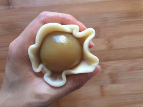压成薄片，将莲蓉蛋黄包住