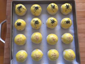 封口朝下放入烤盘，刷上蛋黄液，撒上芝麻，我是两种口味，就撒了不同的芝麻区分