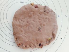 面团取出后平均分成2份揉圆盖保鲜膜松弛15分钟后取一份面团擀成牛舌形。