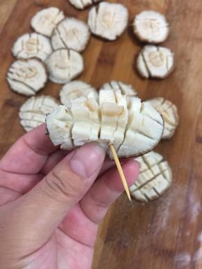 把香菇对折，用牙签固定。