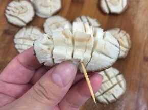 把香菇对折，用牙签固定。