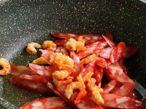 油热，腊肠、海米入锅炒至腊肠变成透明状。