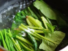 汤锅加水烧开后，加少许盐和几滴油，下入菠菜段煮30秒，至菠菜变软即可。加入油和盐可以让菠菜保持碧绿的颜色。