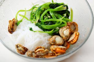 烫软的粉丝和焯水后的菠菜，都挤干水分，和扇贝一起放入料理盆里，