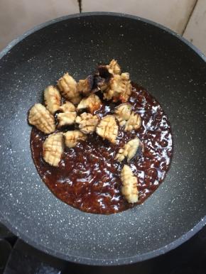 倒入炸好的香菇搅拌均匀使每个香菇都均匀的裹满料汁儿。