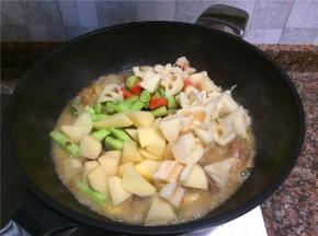 放入四季豆、土豆、莲藕和胡萝卜翻匀，小火煮至汤汁收干一半。