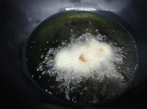 炒锅里放入多一点的油烧至七成热时，把牙签肉放入锅中，炸成金黄色