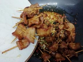 再把炸好的牙签肉放入锅中翻炒片刻