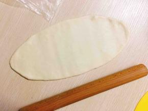 松弛好的面团，手上粘一点手粉轻拍面团，然后用擀面杖轻轻的擀开