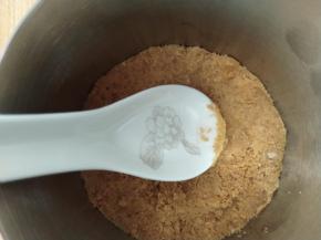 准备一张锡纸，包住慕斯圈底部，然后把搅拌好的饼干碎倒入，用刮刀压平，然后放入冰箱冷藏凝固。