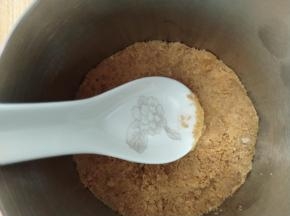 准备一张锡纸，包住慕斯圈底部，然后把搅拌好的饼干碎倒入，用刮刀压平，然后放入冰箱冷藏凝固。