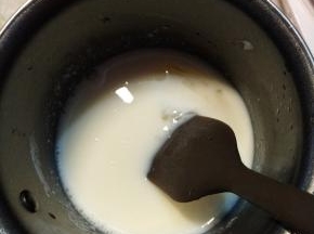 牛奶隔水加热，关火后，加入软化的吉利丁片，利用余热融化搅拌均匀。