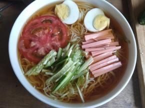 把冷面沥水放入碗内，火腿切丝，熟鸡蛋切成两半，避免浪费就全放进去了，黄瓜切丝，西红柿一片即可，全部配料摆入碗内，家里有辣白菜跟梨的话更佳。