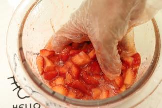 带上一次性手套，将草莓和砂糖拌匀，一边拌一边捏碎