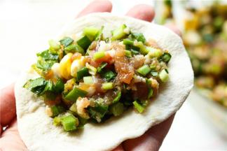 取一个饺子皮，放上适量肉馅。