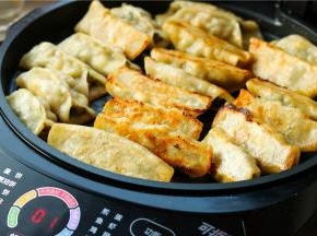 接下来等剩余一分钟的时候，打开盖子，翻一下，让表面也略微煎一下，两面焦黄就可以了，特别好吃的猪肉玉米锅贴就做好了。