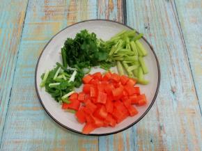 胡萝卜洗干净去皮，切成和花生米一样大的块，香芹洗干净用刀拍几下，然后切成小段，香菜和小葱切成段