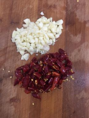 蒜瓣剥皮剁碎，干辣椒洗干净切成段备用。