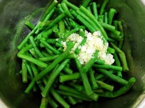 豆角沥干水倒入盆里，加入姜蒜水