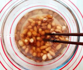 倒入开水之后用筷子快速的搅拌，这时你会看见一些花生皮已经开始脱离出来了，用筷子快速搅拌的优点就是更容易去皮