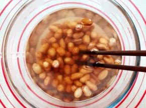 倒入开水之后用筷子快速的搅拌，这时你会看见一些花生皮已经开始脱离出来了，用筷子快速搅拌的优点就是更容易去皮