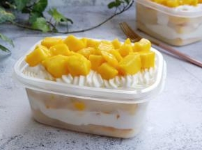 烤好的蛋糕彻底凉透，切小块放入盒子，再挤一次奶油、放一层芒果粒一次类推。