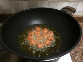 将肉丸再翻面炸制，直至整个肉丸都变成金黄色。
