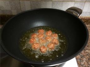 将肉丸再翻面炸制，直至整个肉丸都变成金黄色。