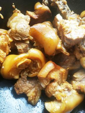 热锅放油，小火炒冰糖至糖色，放入猪蹄翻炒。