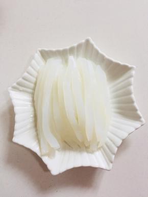 把凉粉切成细条，整齐的码在盘子里。