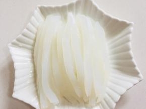 把凉粉切成细条，整齐的码在盘子里。