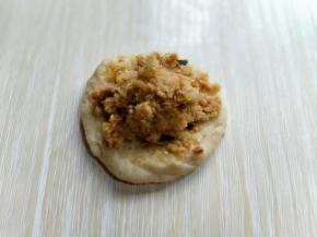 取一块面团，用掌心压扁，放上肉松馅，再包起来！