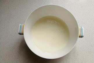 玉米油和牛奶放入容器中，用手动打电器搅拌至乳化状态。