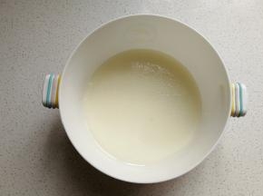 玉米油和牛奶放入容器中，用手动打电器搅拌至乳化状态。