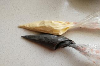 然后把拌好的竹炭蛋糊装入裱花袋中，再取同样分量的原色蛋糊也装入裱花袋备用。