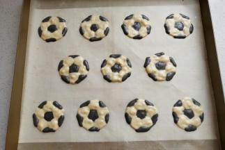 然后把先前画好的足球图形垫在油布或油纸下，再用先前装入裱花袋中的两种蛋糊画出足球图形，画好后把A4稿纸抽出即可。