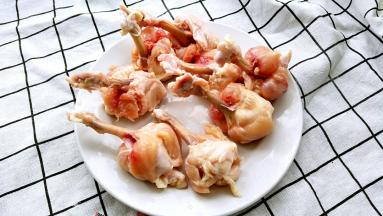 用刀在鸡翅根下方割一圈，将鸡肉推至鸡翅根根部，鸡肉向外翻转包裹住