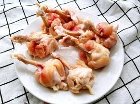 用刀在鸡翅根下方割一圈，将鸡肉推至鸡翅根根部，鸡肉向外翻转包裹住