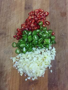 蒜瓣剥皮剁成蒜末，青尖椒和红尖椒切成圈儿备用。