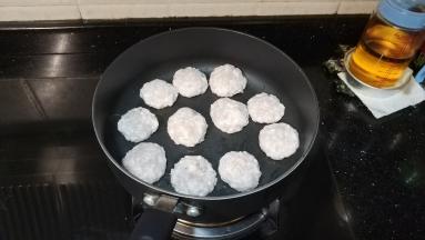 将鱼泥搓成大丸子，再用手轻轻按压成厚0.3厘米的饼状肉饼（手上戴上手套粘点水，防止粘手）

