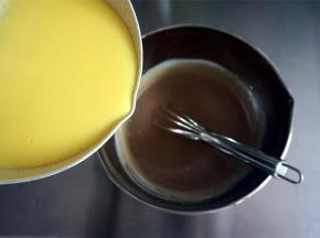 将蛋黄液倒入巧克力淡奶油中，用打蛋器搅拌均匀成为雪糕液。