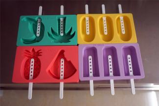 准备硅胶冰棒模具4个，将冰棒棍从里面往外面插入，如图。