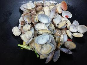 再把洗干净的花甲倒入锅中翻炒片刻，最后加入生抽翻炒均匀即可，关火出锅