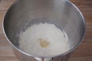 把材料除了黄油外，都放入和面桶，顺序为纯牛奶、鸡蛋液、糖和盐对角放，然后放面粉，酵母放最上面