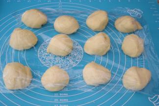 取出面团按压排气揉均匀分成12份，盖上保鲜膜醒发15分钟