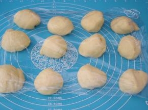 取出面团按压排气揉均匀分成12份，盖上保鲜膜醒发15分钟