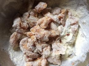 腌制好的鸡肉丁按顺序裹上炸粉