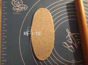 取一个醒好的面剂子擀开成长椭圆片状