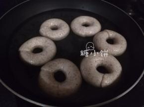 锅内加清水煮开后转小火保持微沸，丢入发酵好的贝果生坯煮20-30秒。翻面再煮20-30秒，然后立刻捞出沥水。