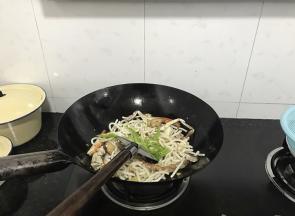 加入面条，继续翻炒。加入辣椒和姜蒜，放好调味料。